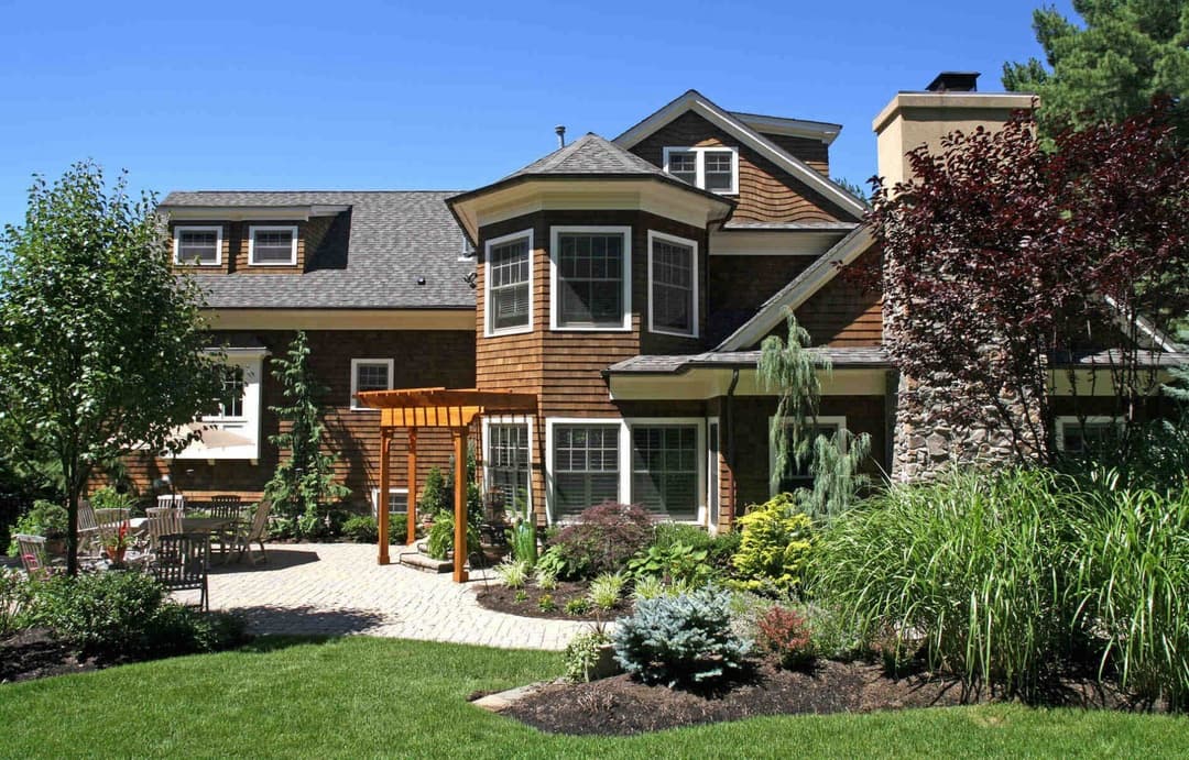 Beautiful modern house with a landscaped yard, patio, and lush greenery. Ideal for outdoor living.