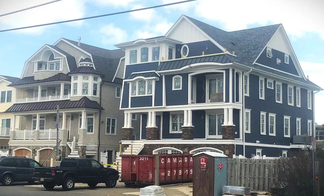 Two large beach houses under construction, showcasing modern architecture and coastal design.