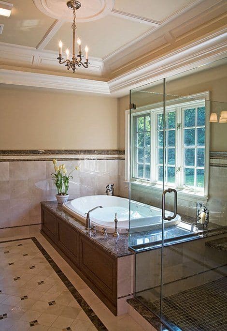 Luxurious bathroom featuring a freestanding tub, glass shower, and elegant chandelier.