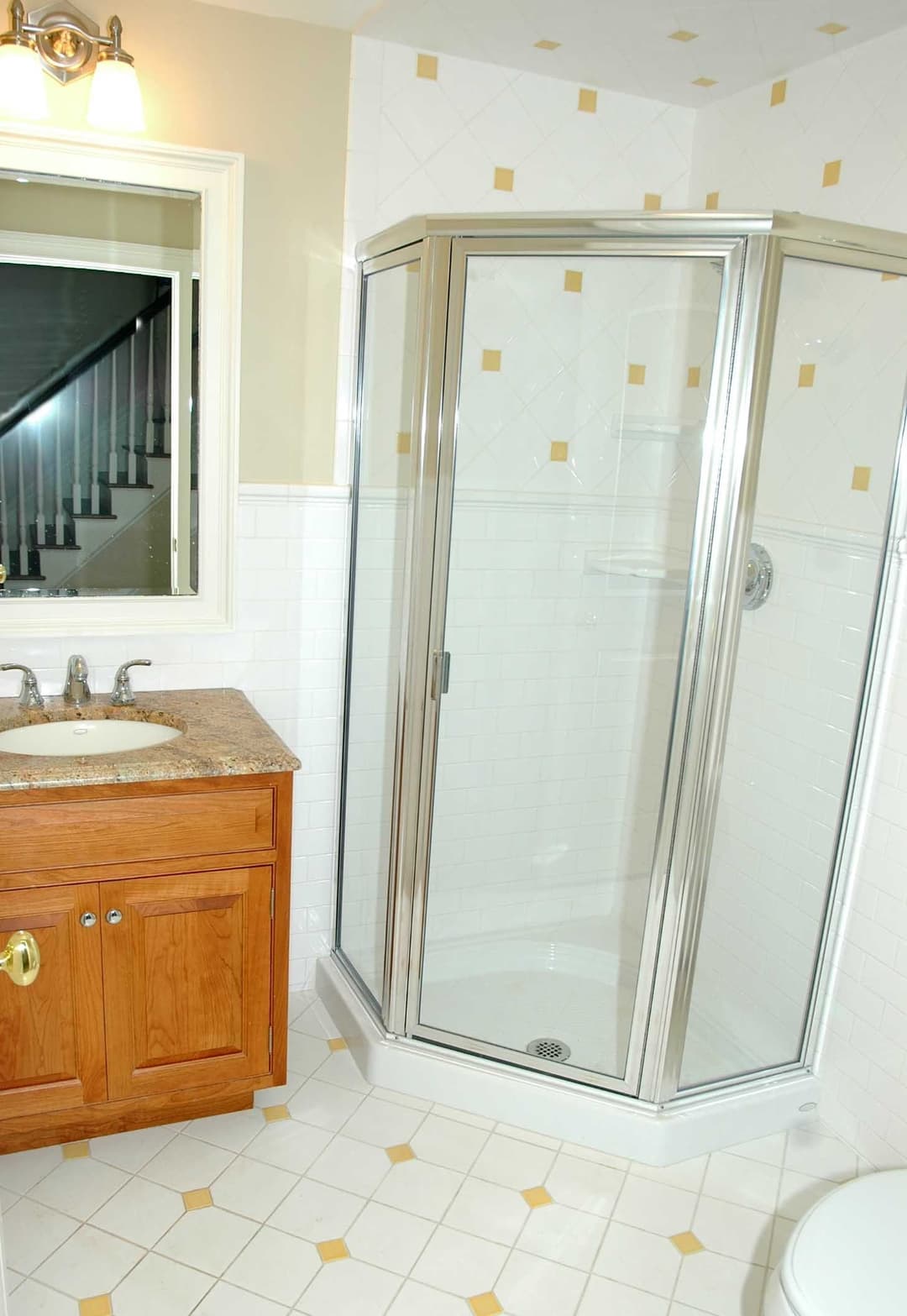 Modern bathroom with a glass shower, wooden vanity, and tiled floor. Bright and spacious design.
