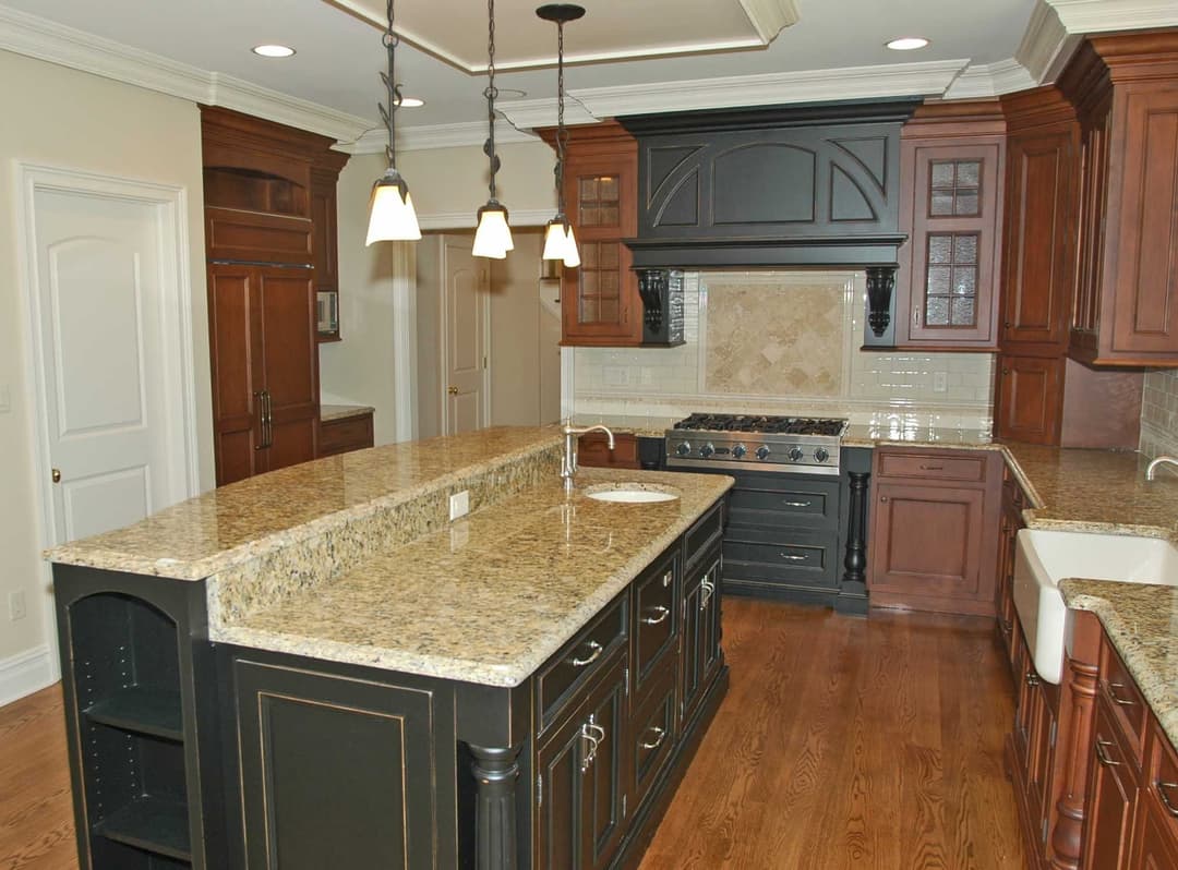 Modern kitchen with dark wood cabinetry, granite countertops, and stainless steel appliances.