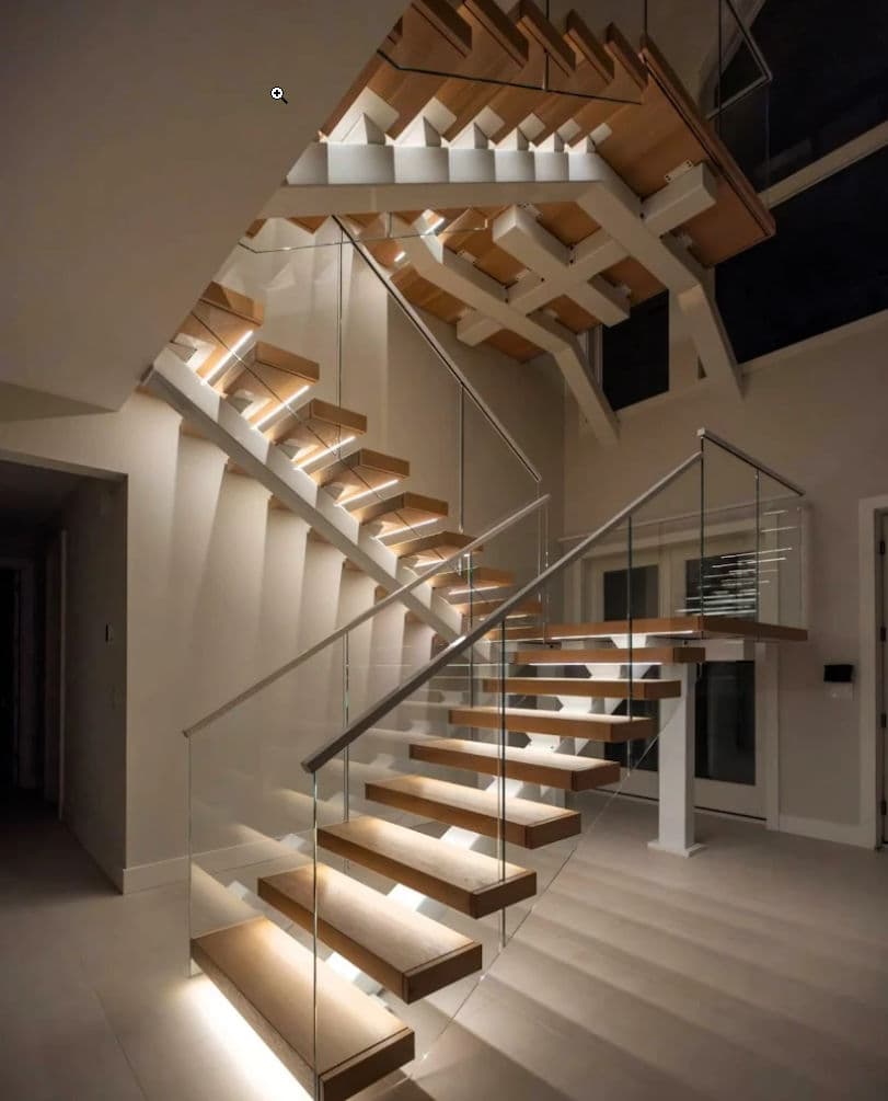Modern wooden staircase with glass railing and LED lighting in contemporary interior design.