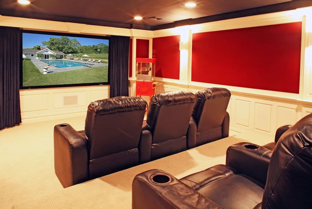 Home theater with leather seating, a large screen, and popcorn machine. Ideal for movie nights.
