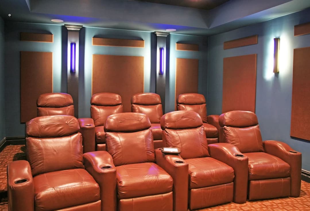 Home theater with plush leather recliners and ambient lighting for an immersive movie experience.