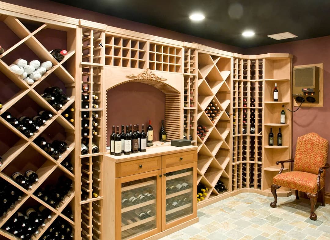 Elegant wine cellar with wooden racks, glass storage, and a cozy armchair.