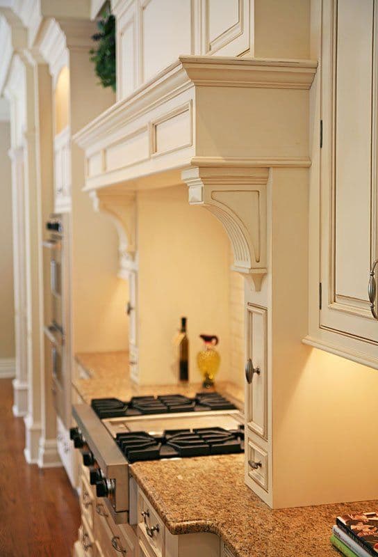 Elegant cream kitchen cabinetry with granite countertops and modern gas stove.
