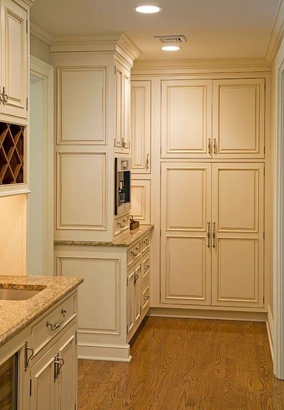 Elegant cream-colored kitchen cabinets with granite countertops and wooden flooring.