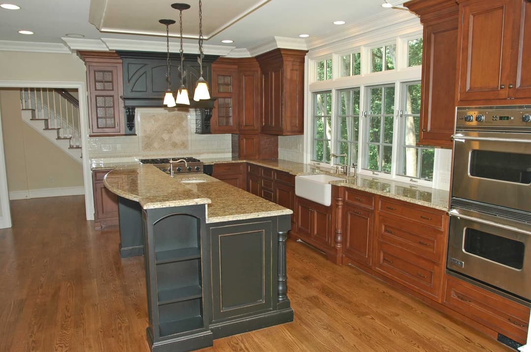 Modern kitchen with dark wood cabinets, granite countertops, and stainless steel appliances.
