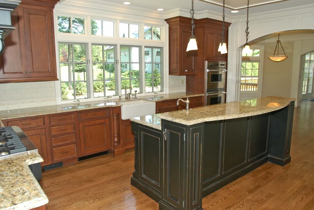 Modern kitchen with wooden cabinets, granite countertops, and large windows for natural light.