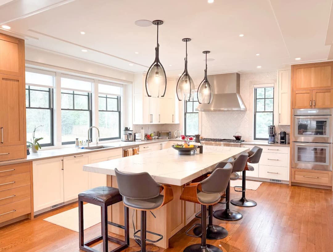 Modern kitchen with island, sleek cabinetry, pendant lights, and ample natural light.