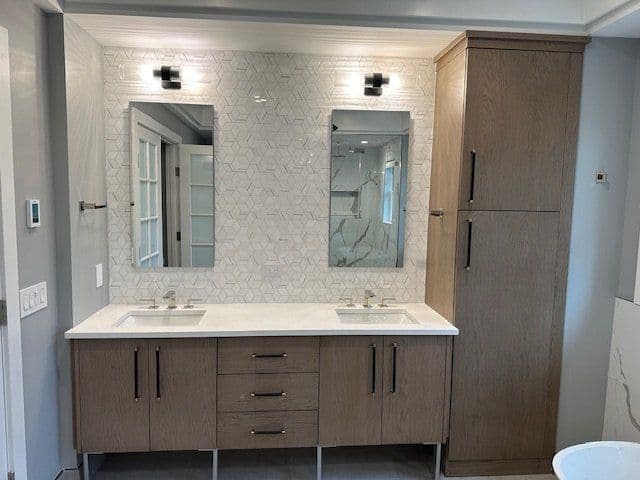 Modern bathroom vanity with dual sinks, mirrors, and hexagonal tile backsplash.
