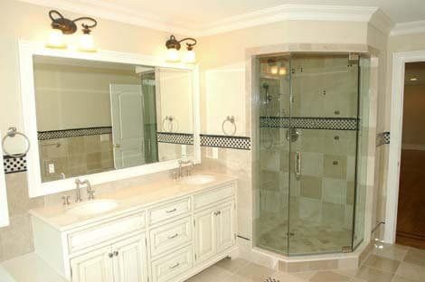 Modern bathroom with double vanity, large mirror, and glass shower enclosure. Elegant design features.