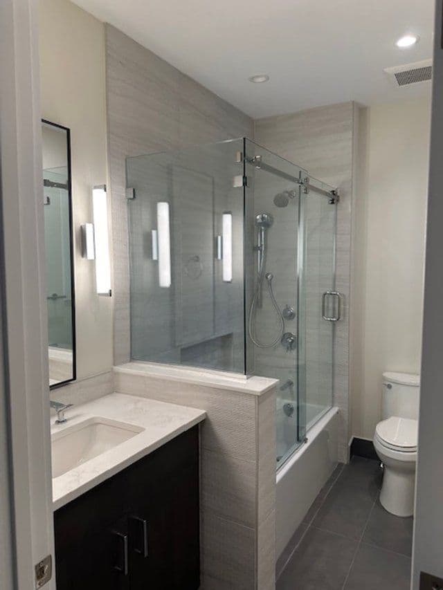 Modern bathroom featuring a glass shower, tub, sink, and stylish lighting.