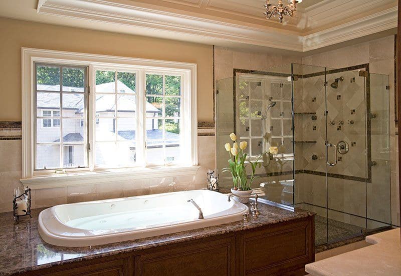 Luxurious bathroom with a soaking tub, glass shower, and large window for natural light.