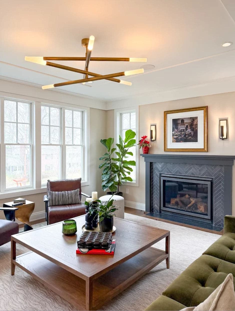 Modern living room with a stylish chandelier, cozy seating, and a sleek fireplace.