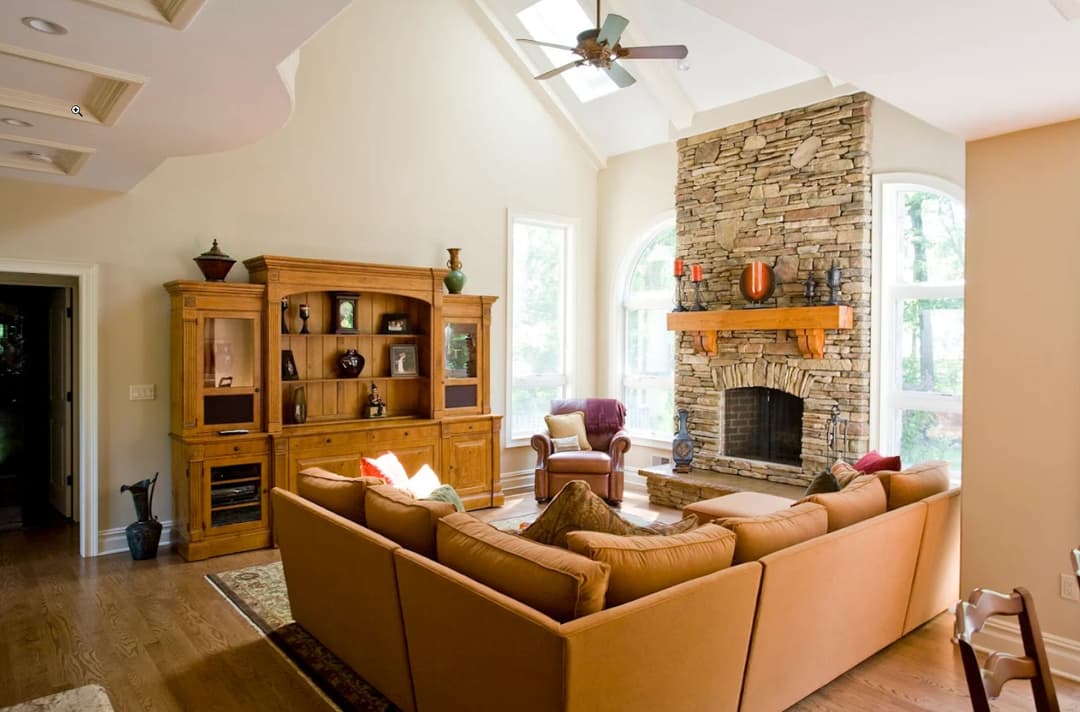 Spacious living room with stone fireplace, large windows, and comfortable furnishings.