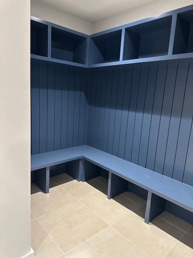 Empty blue locker room with benches and storage cubbies, featuring a modern design.